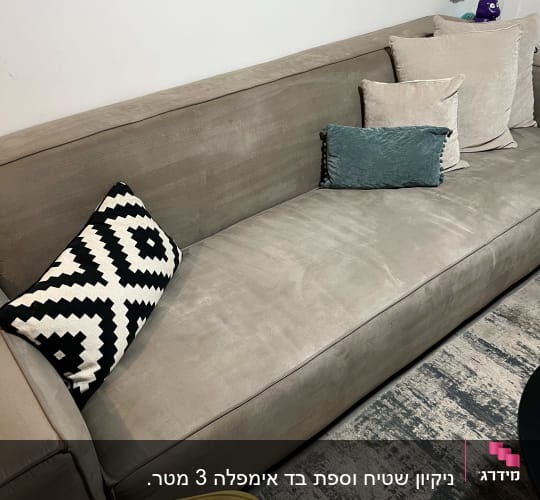 ספה אפורה עם כריות צבעוניות לניקוי
